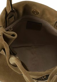 Borsa in camoscio color marrone chiaro con una texture morbida. L'interno presenta una tasca con zip e una fodera in tessuto. La chiusura comprende un bottone a pressione dorato.