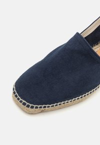 Námornícka kanvasová espadrila s plochou tkanou jutovou podrážkou, s našitým akcentom pozdĺž okraja a štvorcovým dizajnom špičky.
