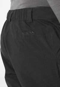 Zwarte outdoor broek met een elastische tailleband en een subtiele "Helly Tech" logo. Gladde textuur met een strakke, functionele uitstraling.