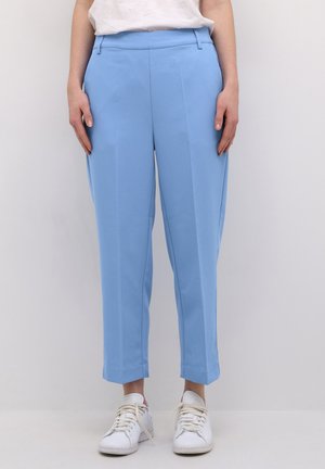 Light blue tailored trousers made of smooth fabric with a straight cut, featuring a waistband and front pleats, paired with white sneakers.