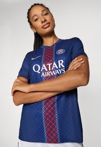 Blue sports jersey made of breathable material, featuring a red geometric pattern and white text for "Qatar Airways." Short sleeves and crew neck.