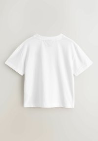 Tricou alb din bumbac cu mâneci scurte și decolteu rotund. Prezintă o croială lejeră și o textură netedă; design simplu, fără modele vizibile.