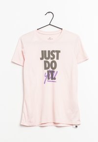 Różowy bawełniany T-shirt wiszący na haczyku, z wyraźnym czarnym napisem "JUST DO" i fioletowymi akcentami z napisem "y' all!" w swobodnym stylu.