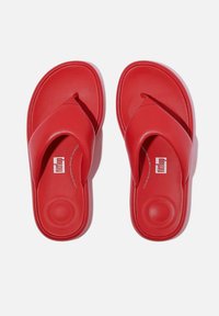 Rode flip-flops met een gladde, matte afwerking. Voorzien van een slipperstijl band en een gevoerde voetbed. Logo zichtbaar op het voetbed.