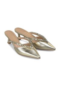 Talons slingback métalliques dorés avec un bout pointu, dotés d'une sangle décorative en rhinestones et d'un petit talon. Texture en cuir lisse.