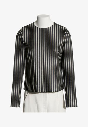 Haut noir à manches longues avec fines rayures verticales blanches, encolure ronde et coupe droite légèrement ample sur un buste de mannequin blanc.