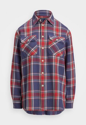 Chemise en flanelle à manches longues boutonnée avec un motif à carreaux rouge, marine et blanc, dotée de deux poches poitrine boutonnées à l'avant.
