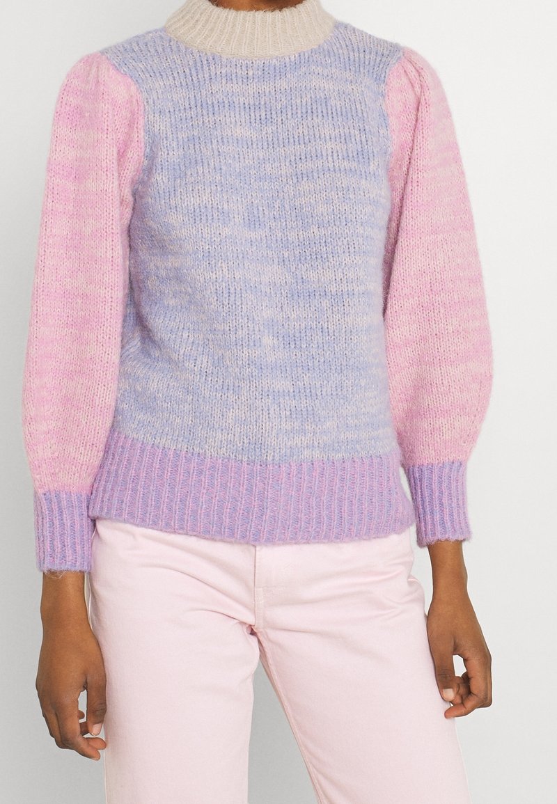 Stickad tröja med en ljuslila och rosa gradient, ribbat detaljer, rund beige krage och puffärmar. Texturerat, mjukt tyg.