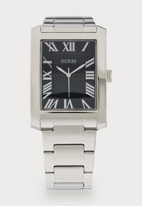 Montre-bracelet en métal argenté avec un cadran noir rectangulaire, des chiffres romains et une finition polie. Présente un design de bracelet à maillons.