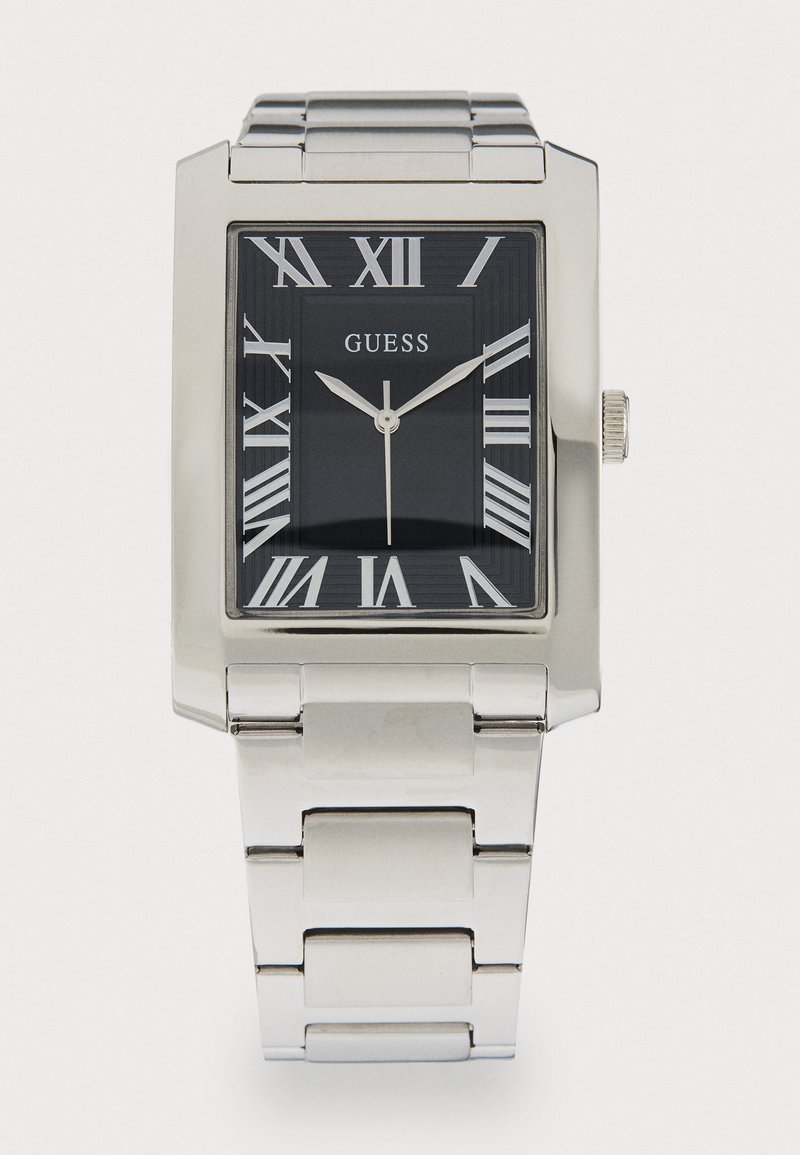 Montre-bracelet en métal argenté avec un cadran noir rectangulaire, des chiffres romains et une finition polie. Présente un design de bracelet à maillons.