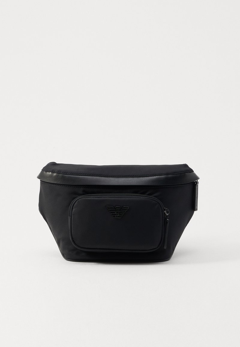 Black nylon bag with a front zip pocket, featuring a smooth texture and a logo accent. Structured design with a fold-over top.