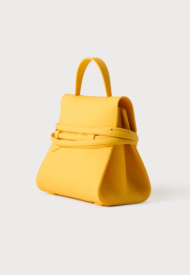 Sac à main structuré jaune avec une poignée supérieure et un détail de ceinture enveloppante, présenté sur un fond clair uni.
