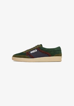 Zapatilla de ante verde y marrón con tejido de navy perforado, suela beige y acentos multicolores a lo largo de los laterales y la lengua.