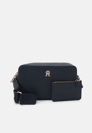 Borsa sintetica blu navy con forma strutturata, accessori in oro e un portacarte rimovibile. Presenta una tracolla in tessuto per un trasporto versatile.