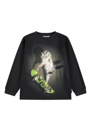 T-shirt noir à manches longues avec un graphisme d'un chat sautant par-dessus un skateboard vert avec des effets d'ombre.