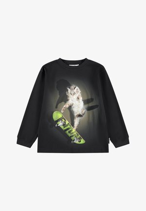 Sort langærmet t-shirt med et billede af en kat, der hopper over et grønt skateboard med skyggereffekter.