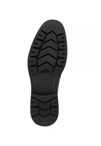 Černá guma podešve s texturovaným vzorem, který obsahuje drážky a výstupky pro lepší přilnavost, označeno "WITTCHEN handmade."