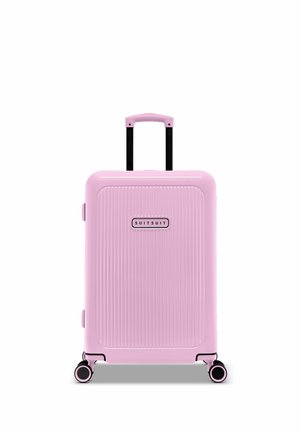 Hard-shell pink suitcase with vertical ribbed texture, black retractable handle, and dual wheels with contrasting accents.