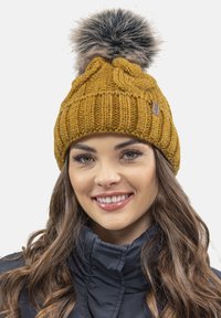 Strikket sennepsgul hue med ribbet tekstur og en stor faux fur pompon på toppen. Har et lille læderlogo på siden.