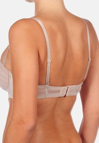 Sujetador beige con tirantes ajustables y un cierre de gancho y ojal en la parte posterior. Material suave con paneles transparentes. Diseñado para la comodidad.