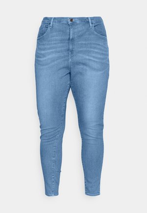 Jean en denim bleu clair au design ajusté. Comprend une fermeture à bouton, cinq poches et une texture légèrement décolorée.