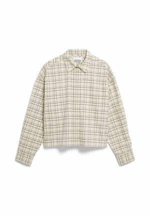 Chemise courte boutonnée en tissu beige clair avec motif à carreaux noirs, dotée d'un col pointu et d'une poche poitrine unique.