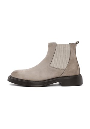 Botas Chelsea de ante gris claro con paneles laterales elásticos, puntera redondeada y suela de goma negra. Cuenta con una lengüeta trasera para facilitar su colocación.