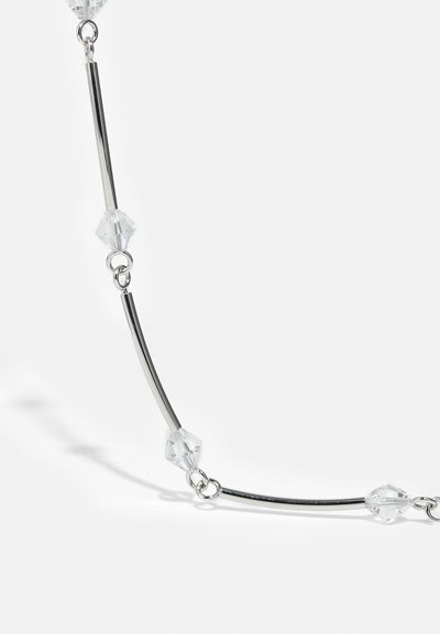 Collana d'argento con anelli di metallo curvi intervallati da perline geometriche trasparenti, creando un design semplice ma elegante.