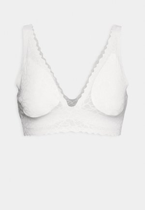 Bralette bianco in pizzo con scollatura a V profonda, bordi ondulati e coppe morbide. Il tessuto presenta un motivo floreale testurizzato.