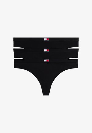 Trois culottes string noires empilées, chacune avec un petit logo rectangulaire rouge, blanc et bleu Tommy Hilfiger sur la ceinture.