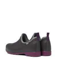 Chaussures noires en caoutchouc à enfiler avec une semelle violette et des finitions grises, présentant un design arrondi et une languette pour un enfilage facile.
