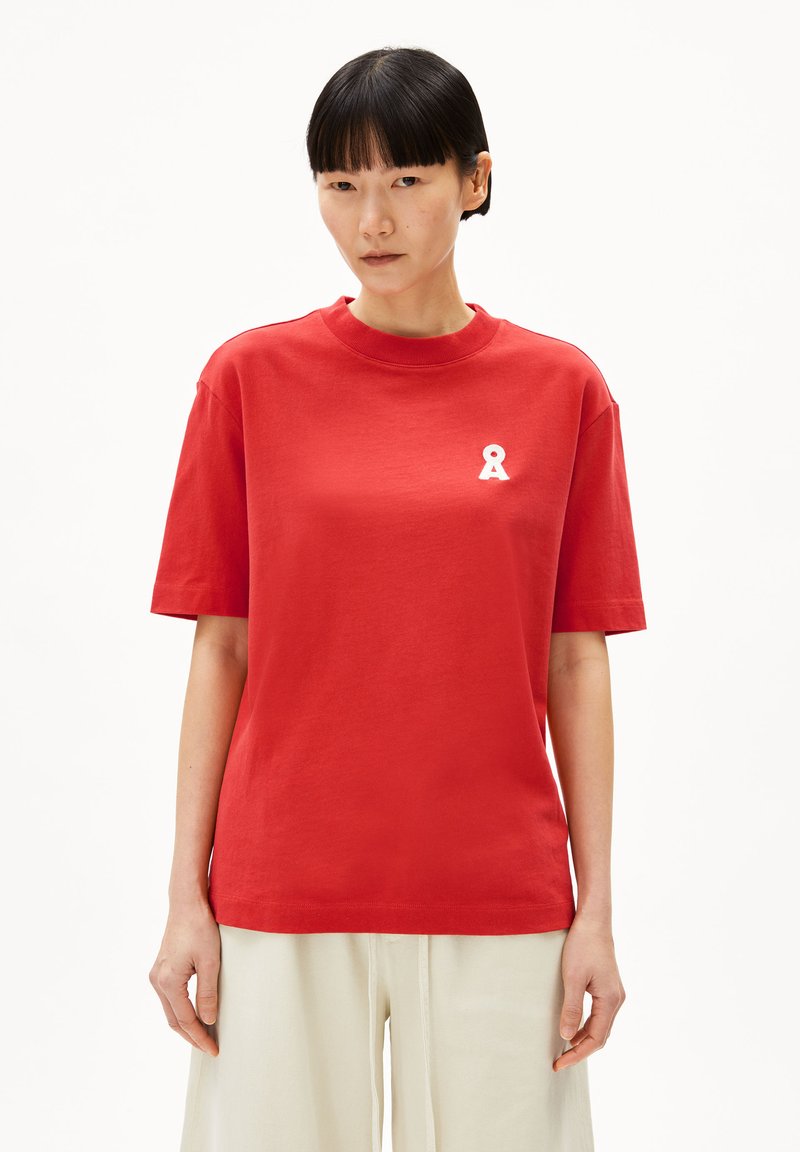 T-shirt rossa in cotone con colletto tondo ribattuto e maniche corte. Presenta un piccolo logo a nastro bianco sul lato sinistro del petto.