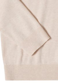 Gros plan d’une manche de pull beige en tricot avec un poignet côtelé, montrant la texture et les détails du tissu.