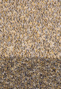 Strickstoff mit einem Fischgrätenmuster in Gelb-, Weiß- und Grautönen, der unterschiedliche Texturen und eine leicht lockere Webart aufweist.