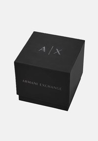 Must kast musta viimistlusega, mille peal on reljeefne hõbedane kiri "A/X" ja ees "ARMANI EXCHANGE".