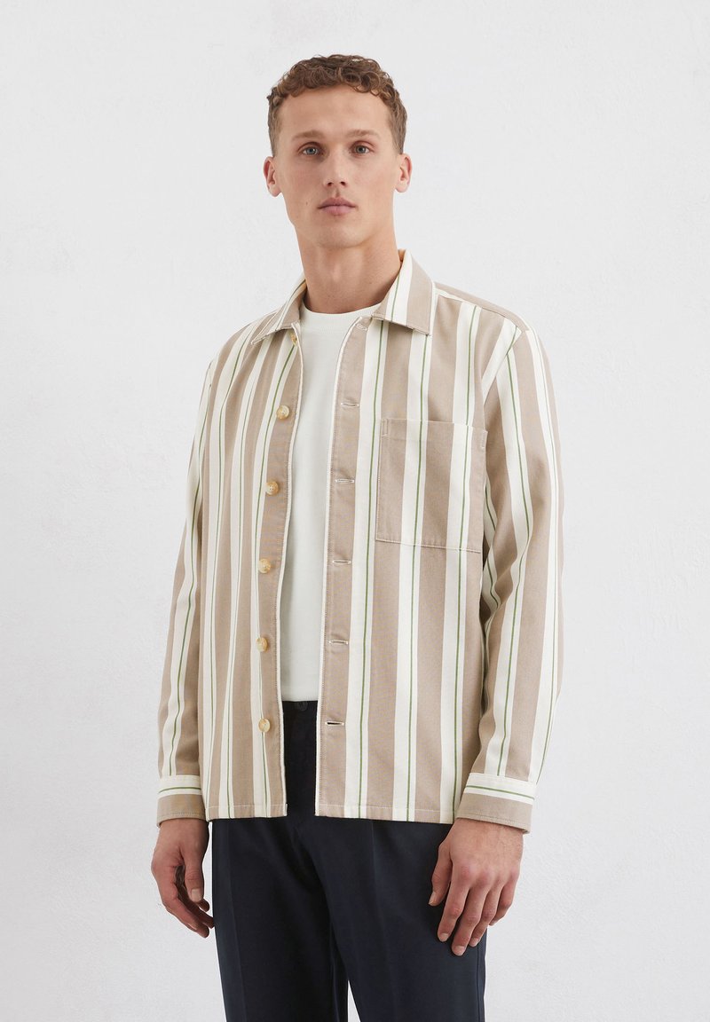 Gestreept overhemdd met beige, witte en groene kleuren. Heeft een borstzak en een rechte kraag. Gemaakt van een zachte, textuurstof.