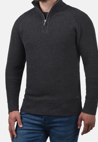 Dunkelgrauer, gestrickter Pullover mit halbem Reißverschluss am Kragen, gerippten Bündchen und Bund. Verfügt über ein strukturiertes Strickmuster und ein dezentes Markenlogo am Saum.