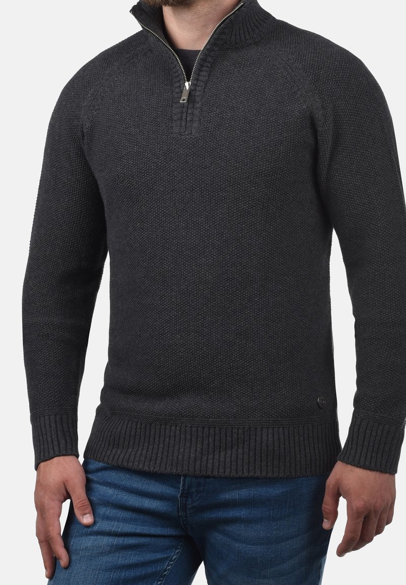 Dunkelgrauer, gestrickter Pullover mit halbem Reißverschluss am Kragen, gerippten Bündchen und Bund. Verfügt über ein strukturiertes Strickmuster und ein dezentes Markenlogo am Saum.