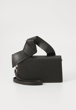 Black leather bag with a rectangular shape, featuring a unique knotted handle and a detachable shoulder strap. Smooth texture and minimal seams.