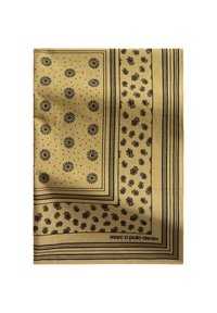 Żółty szalik z czarnymi wzorami kwiatowymi i paskami, z logo w prawym dolnym rogu. Gładka tekstura i kwadratowy kształt.