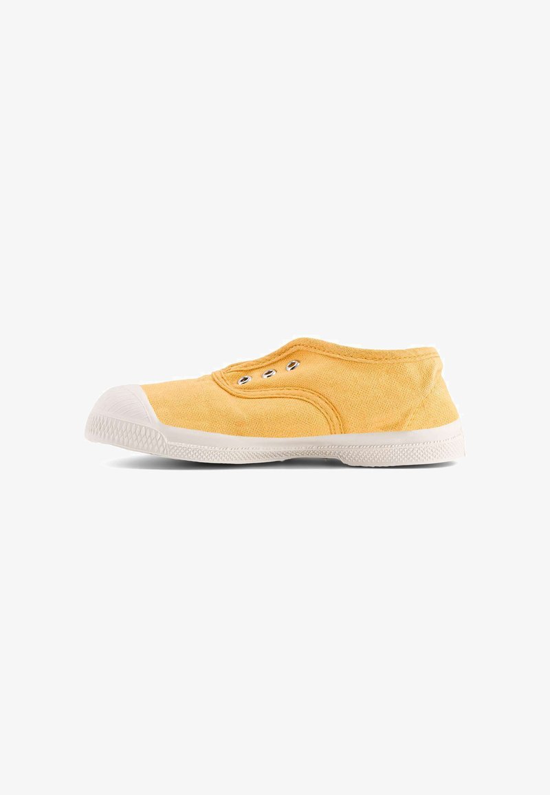 Baskets à enfiler en toile jaune avec semelle et bout en caoutchouc blanc, œillets en métal, et sans lacets sur fond blanc.