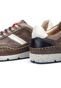 Zapatillas de cuero marrón con una superficie texturada, acentos blancos, costuras beige y suelas de goma moteadas. Diseño de caña baja con cordones.