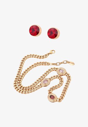 Guldkæde med tre ovale farvede ædelstene og matchende runde røde ædelstensnitteøreringe på hvid baggrund.