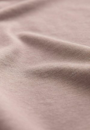 Vaaleanpunainen kangas, jossa on sileä, hieman teksturoitu pinta. Materiaalissa on hienoa vaakasuoraa uritusta, mikä luo pehmeän laskeutuman.