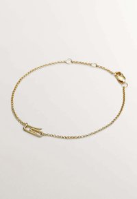 Pulsera de tono dorado con un delicado eslabón, que presenta un charm central en forma de clip de papel. Diseño simple con cierre de langosta.