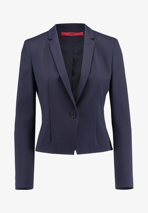 Blazer azul marino para mujer, entallado, con mangas largas, cierre con un solo botón negro y etiqueta interior roja.