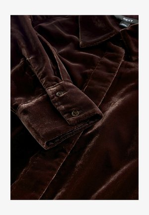 Braunes Samtshirt mit Kragen, geknöpften Manschetten mit dunklen Knöpfen, glatter Textur und klassischem Design.