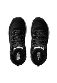 Μαύρα παπούτσια πεζοπορίας με υφασμάτινο επάνω μέρος με υφή, λευκή λάστιχη σόλα, μεταλλικά κορδόνια και λογότυπο στη γλώσσα και στην εσωτερική σόλα.