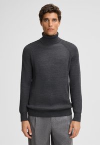 Dunkelgrauer Strickrollkragenpullover mit gerippter Textur, langen Ärmeln und taillierter Silhouette. Minimalistisches Design ohne sichtbare Muster.