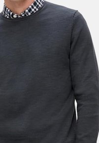 Donkergrijze sweatshirt met ronde hals, waaronder een zwart-wit geruit overhemd is gelaagd. Soepele textuur, casual ontwerp.
